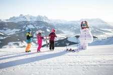Kinder mit Maskottchen Valle im Skigebiet